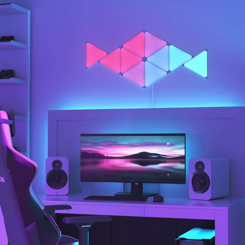 Nanoleaf Shapes Thread-enabled color-changing triangle smart modular light panels mounted to a wall above a battlestation. Similar to Philips Hue, Lifx. HomeKit, Google Assistant, Amazon Alexa, IFTTT. 